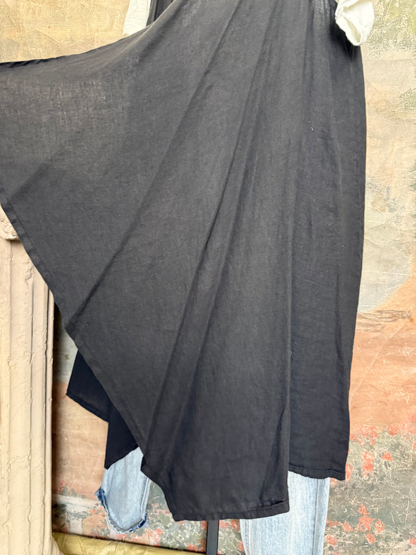 Long black sleeveless open front duster vest styled with graphic tee, gingham pants, and black beaded necklace on hanger - 6