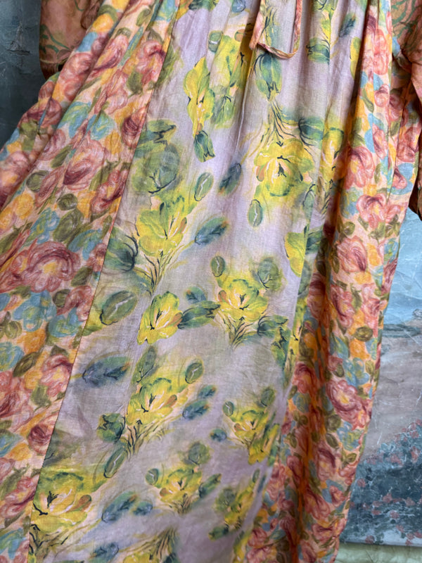 Woman wearing DYM90081 Bloomspell Maxi Dress in orange floral print with pink Converse sneakers in boutique setting - 8