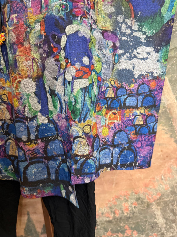 Oversized crew pullover in vibrant multicolor abstract print with flower necklace, paired with black pants on mannequin - 7