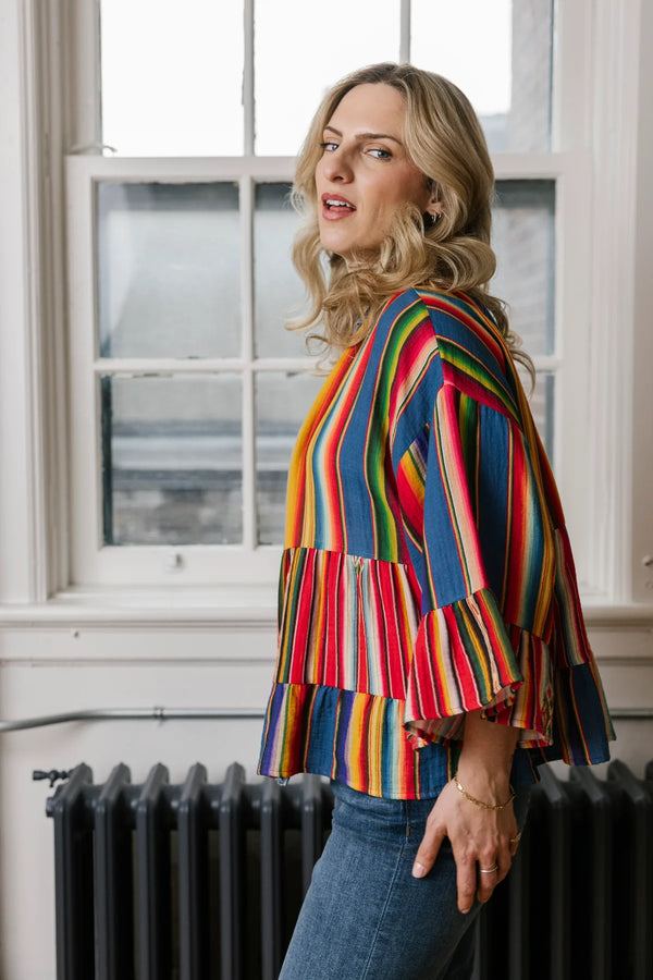 Woman wearing Stella Cardigan 5860 with rainbow serape stripes, denim trim, ruffle hem, and bell sleeves over white tee - 2