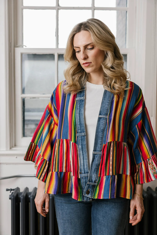 Woman wearing Stella Cardigan 5860 with rainbow serape stripes, denim trim, ruffle hem, and bell sleeves over white tee - 1