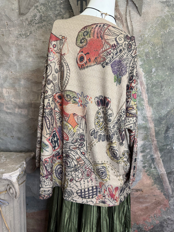 Boho waffle knit tunic top with abstract art print in earthy tones, styled with colorful chain necklace on mannequin - 12