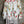 Load image into Gallery viewer, White floral kimono cardigan with pink roses and crochet lace trim displayed over gray tank top on hanger - 4
