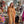 Load image into Gallery viewer, Woman wearing DYM90081 Bloomspell Maxi Dress in orange floral print with pink Converse sneakers in boutique setting - 1

