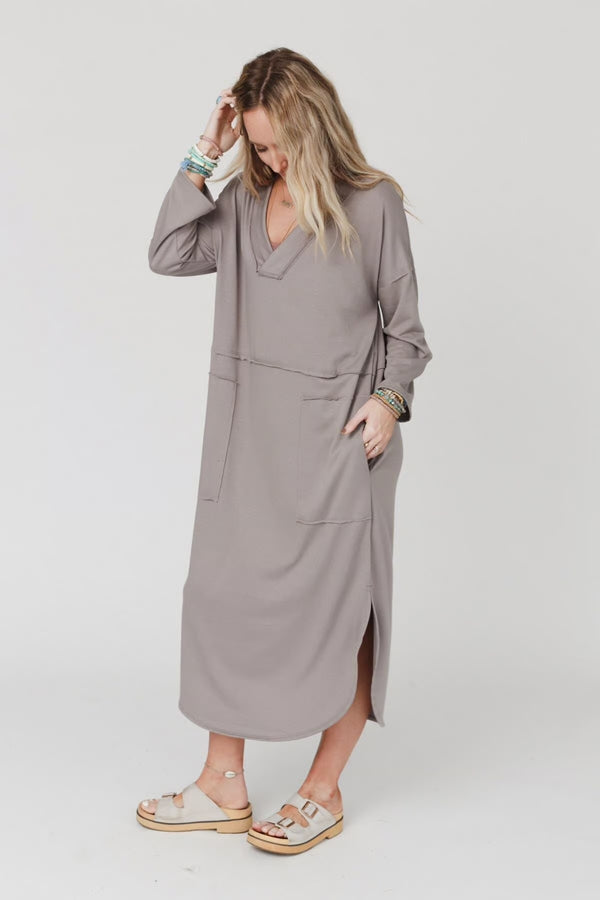 Woman wearing taupe long sleeve V-neck maxi dress with pockets and side slit, styled with platform sandals - 7