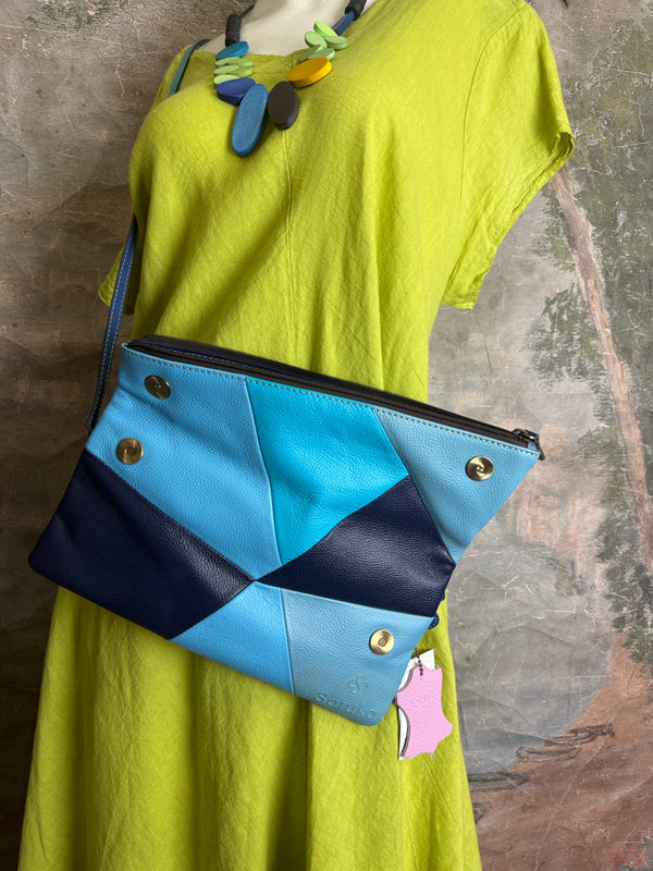 Mila color-block crossbody bag in teal, blue, and navy leather with turquoise strap, styled on mannequin with lime dress - 7