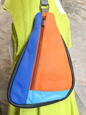 Soruka Roxy leather sling crossbody bag in bold blue, orange, and turquoise colorblock with zip closure on mannequin - 2