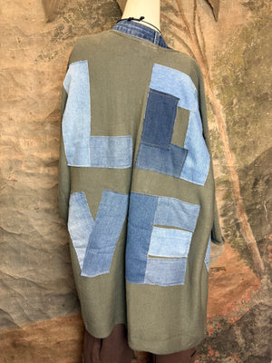 Olive green ribbed cotton cardigan with denim patchwork LOVE letters on back, displayed on mannequin - 3