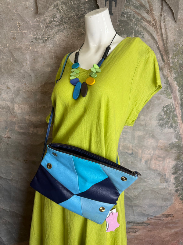 Mila color-block crossbody bag in teal, blue, and navy leather with turquoise strap, styled on mannequin with lime dress - 5