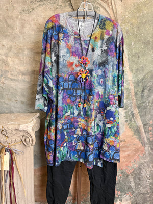 Oversized crew pullover in vibrant multicolor abstract print with flower necklace, paired with black pants on mannequin - 2
