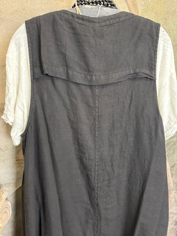 Long black sleeveless open front duster vest styled with graphic tee, gingham pants, and black beaded necklace on hanger - 8