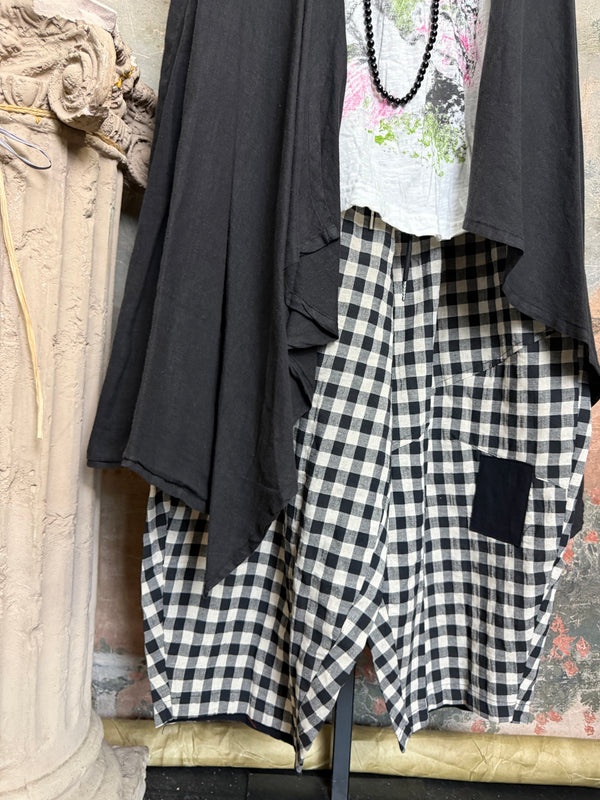 Long black sleeveless open front duster vest styled with graphic tee, gingham pants, and black beaded necklace on hanger - 10