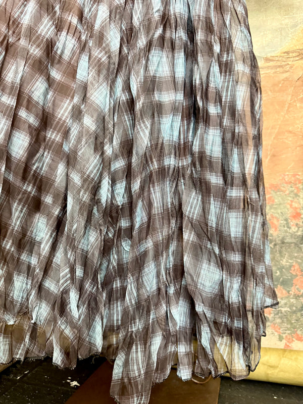 Flowy plaid midi skirt in blue-gray tones styled with patched denim jacket and pearl necklace on boutique display - 6