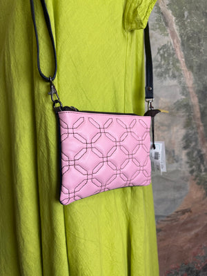 Pink leather quilted crossbody bag with geometric stitching pattern and black adjustable strap on lime green dress - 1