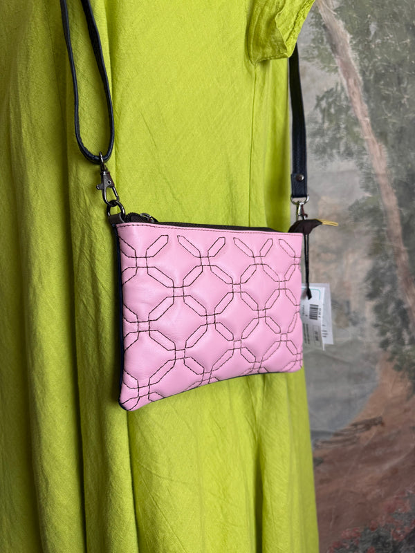 Pink leather quilted crossbody bag with geometric stitching pattern and black adjustable strap on lime green dress - 1