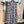 Load image into Gallery viewer, Flowy plaid midi skirt in blue-gray tones styled with patched denim jacket and pearl necklace on boutique display - 2
