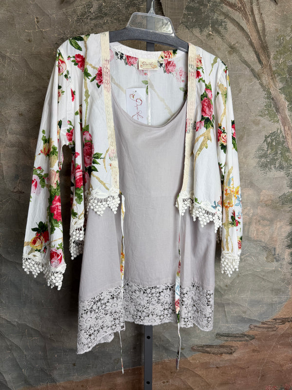 White floral kimono cardigan with pink roses and crochet lace trim displayed over gray tank top on hanger - 1
