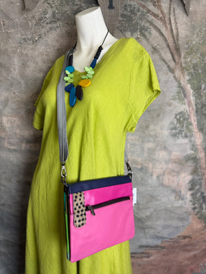 Soruka Mei crossbody bag in pink and navy leather with polka dot detail on mannequin with lime green dress - 1