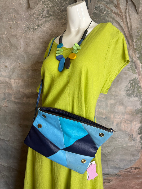 Mila color-block crossbody bag in teal, blue, and navy leather with turquoise strap, styled on mannequin with lime dress - 6