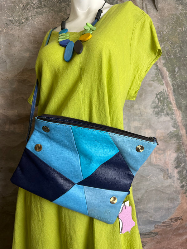 Mila color-block crossbody bag in teal, blue, and navy leather with turquoise strap, styled on mannequin with lime dress - 10