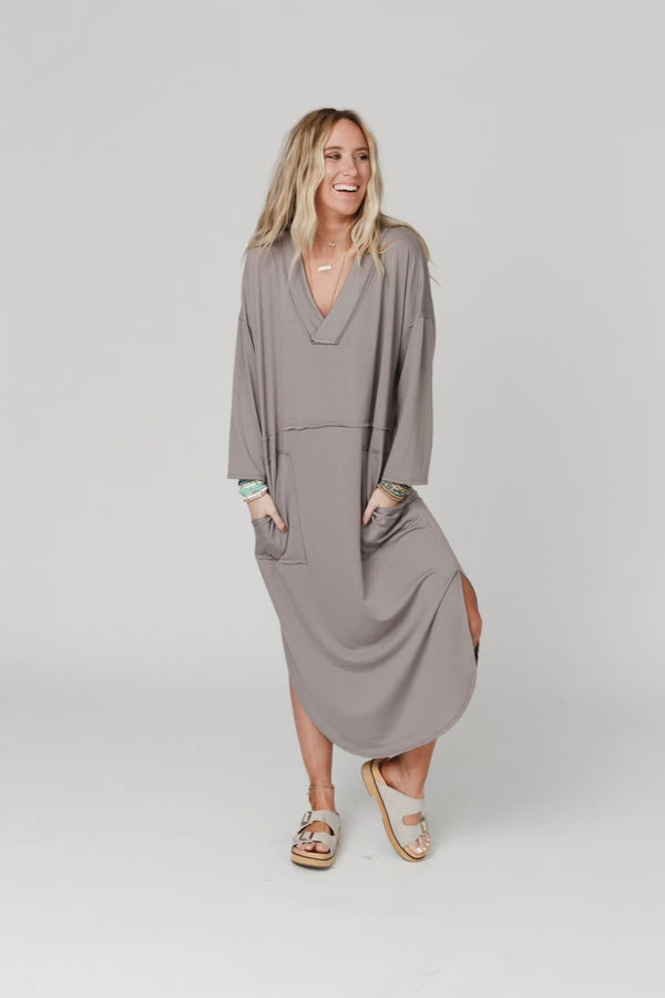 Woman wearing taupe long sleeve V-neck maxi dress with pockets and side slit, styled with platform sandals - 6