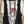Load image into Gallery viewer, Long black sleeveless open front duster vest styled with graphic tee, gingham pants, and black beaded necklace on hanger - 4
