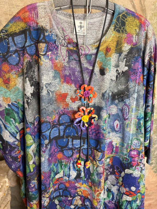 Oversized crew pullover in vibrant multicolor abstract print with flower necklace, paired with black pants on mannequin - 5
