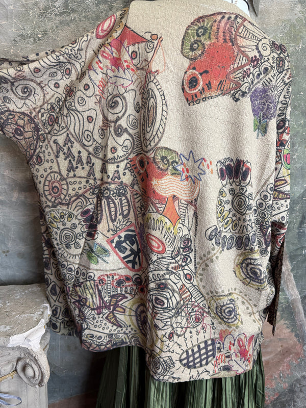 Boho waffle knit tunic top with abstract art print in earthy tones, styled with colorful chain necklace on mannequin - 11