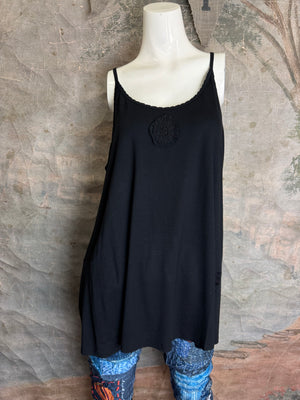 Black spaghetti strap cami tank dress with decorative lace medallion detail, worn over patchwork print leggings - 1