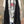 Load image into Gallery viewer, Long black sleeveless open front duster vest styled with graphic tee, gingham pants, and black beaded necklace on hanger - 2
