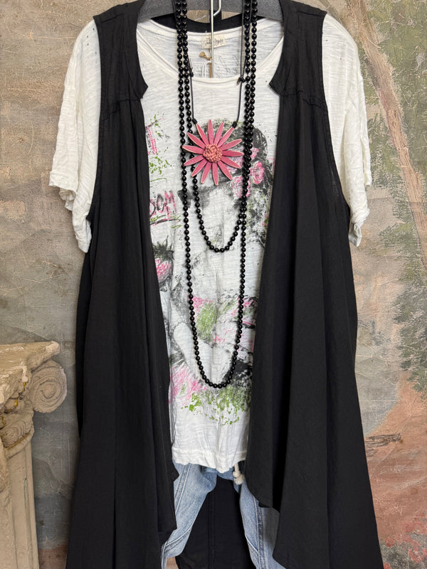 Long black sleeveless open front duster vest styled with graphic tee, gingham pants, and black beaded necklace on hanger - 2