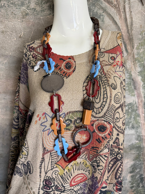 Boho waffle knit tunic top with abstract art print in earthy tones, styled with colorful chain necklace on mannequin - 2