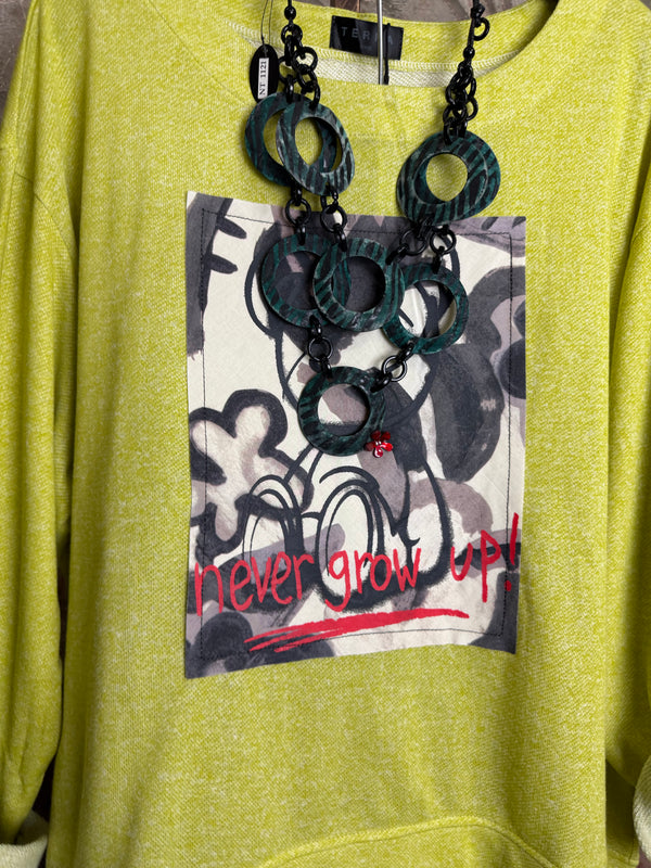 Lime green knit top with Never Grow Up graphic print, styled with green chain ring necklace and olive pleated skirt - 5
