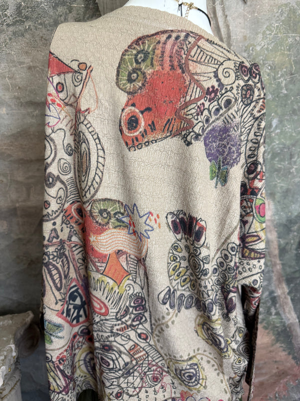 Boho waffle knit tunic top with abstract art print in earthy tones, styled with colorful chain necklace on mannequin - 9