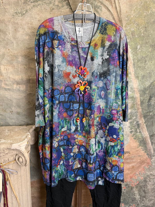 Oversized crew pullover in vibrant multicolor abstract print with flower necklace, paired with black pants on mannequin - 8