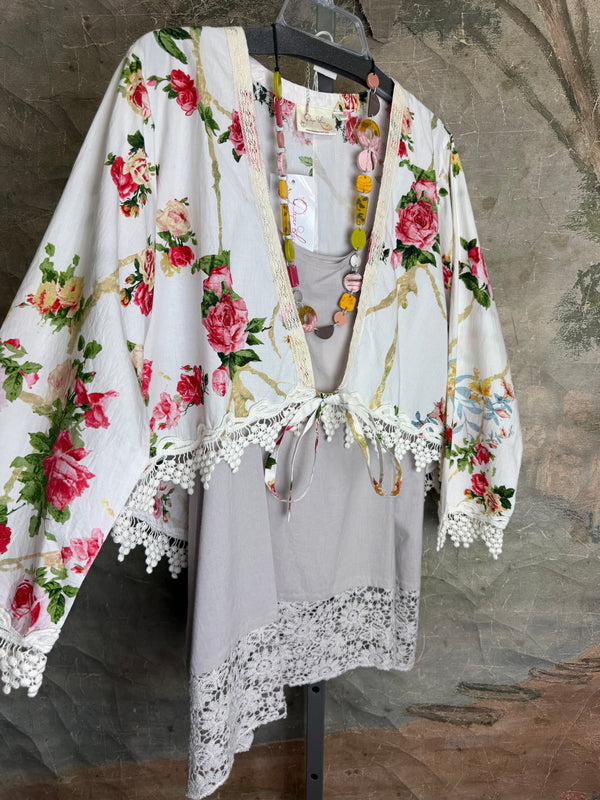 White floral kimono cardigan with pink roses and crochet lace trim displayed over gray tank top on hanger - 3