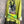 Load image into Gallery viewer, Lime green knit top with Never Grow Up graphic print, styled with green chain ring necklace and olive pleated skirt - 4
