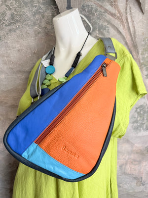 Soruka Roxy leather sling crossbody bag in bold blue, orange, and turquoise colorblock with zip closure on mannequin - 1
