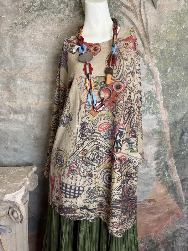 Boho waffle knit tunic top with abstract art print in earthy tones, styled with colorful chain necklace on mannequin - 1