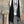 Load image into Gallery viewer, Long black sleeveless open front duster vest styled with graphic tee, gingham pants, and black beaded necklace on hanger - 1
