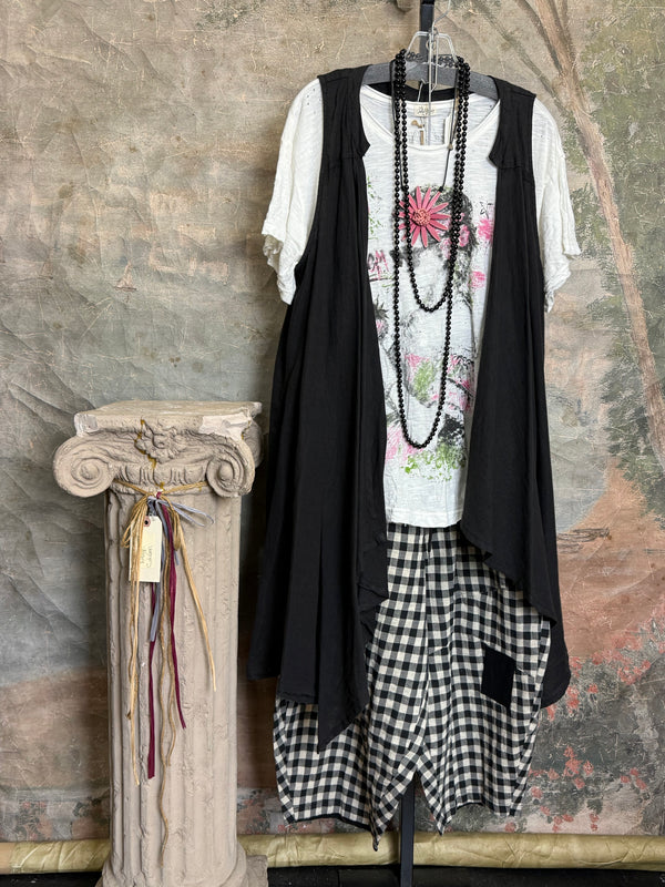 Long black sleeveless open front duster vest styled with graphic tee, gingham pants, and black beaded necklace on hanger - 1
