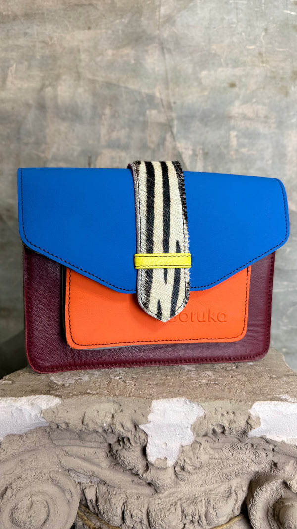 Goruka Grace Reversible Loop-B colorblock leather bag in blue, burgundy, orange with zebra print strap on stone column - 2