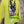 Load image into Gallery viewer, Lime green knit top with Never Grow Up graphic print, styled with green chain ring necklace and olive pleated skirt - 3
