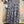 Load image into Gallery viewer, Flowy plaid midi skirt in blue-gray tones styled with patched denim jacket and pearl necklace on boutique display - 7
