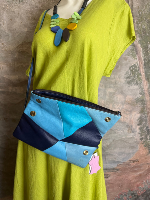Mila color-block crossbody bag in teal, blue, and navy leather with turquoise strap, styled on mannequin with lime dress - 9