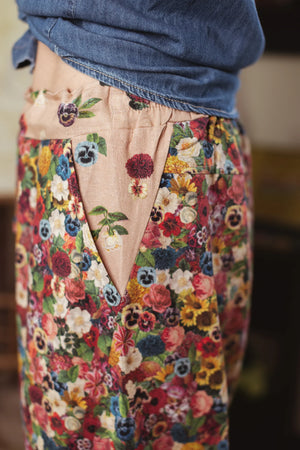 Woman wearing MOTS Linen Crop Artist Pant in colorful floral print with tied denim shirt in bohemian styled room - 4