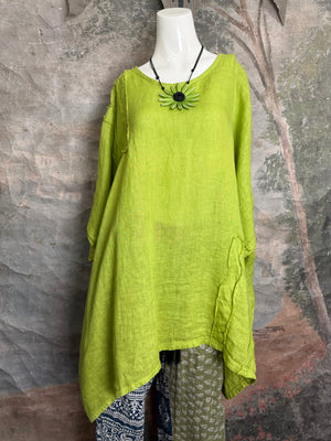 Oversized lime green linen tunic top with asymmetric hem and flower pendant necklace on white mannequin - 12
