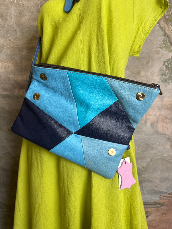 Mila color-block crossbody bag in teal, blue, and navy leather with turquoise strap, styled on mannequin with lime dress - 8