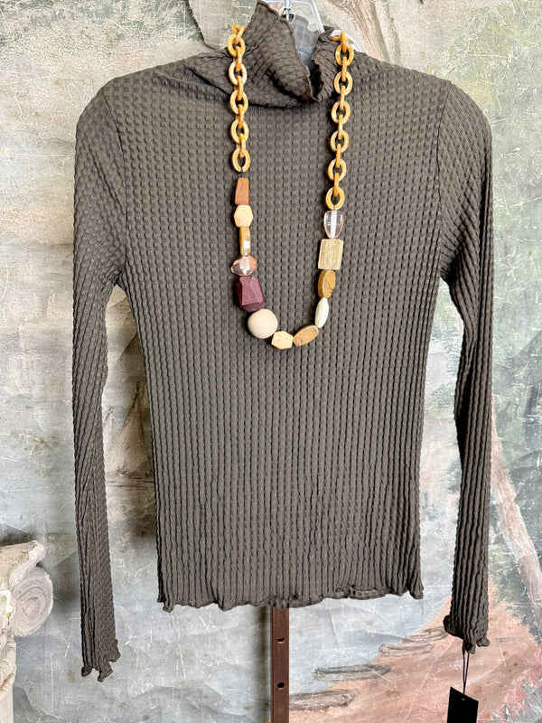 Olive green waffle knit turtleneck long sleeve fitted top displayed with chunky beaded statement necklace on hanger - 2