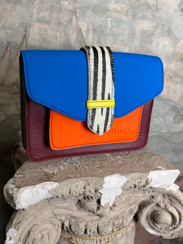 Goruka Grace Reversible Loop-B colorblock leather bag in blue, burgundy, orange with zebra print strap on stone column - 10